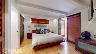 a bedroom with a bed and a dresser next to a window