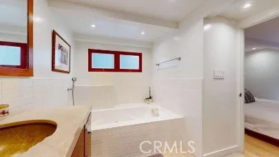 a bathroom with a tub sink and mirror