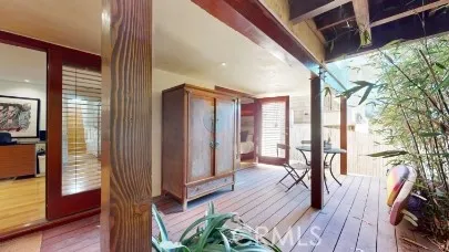 a view of a hallway with wooden floor and furniture