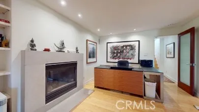 a living room with stainless steel appliances furniture a fireplace and a flat screen tv