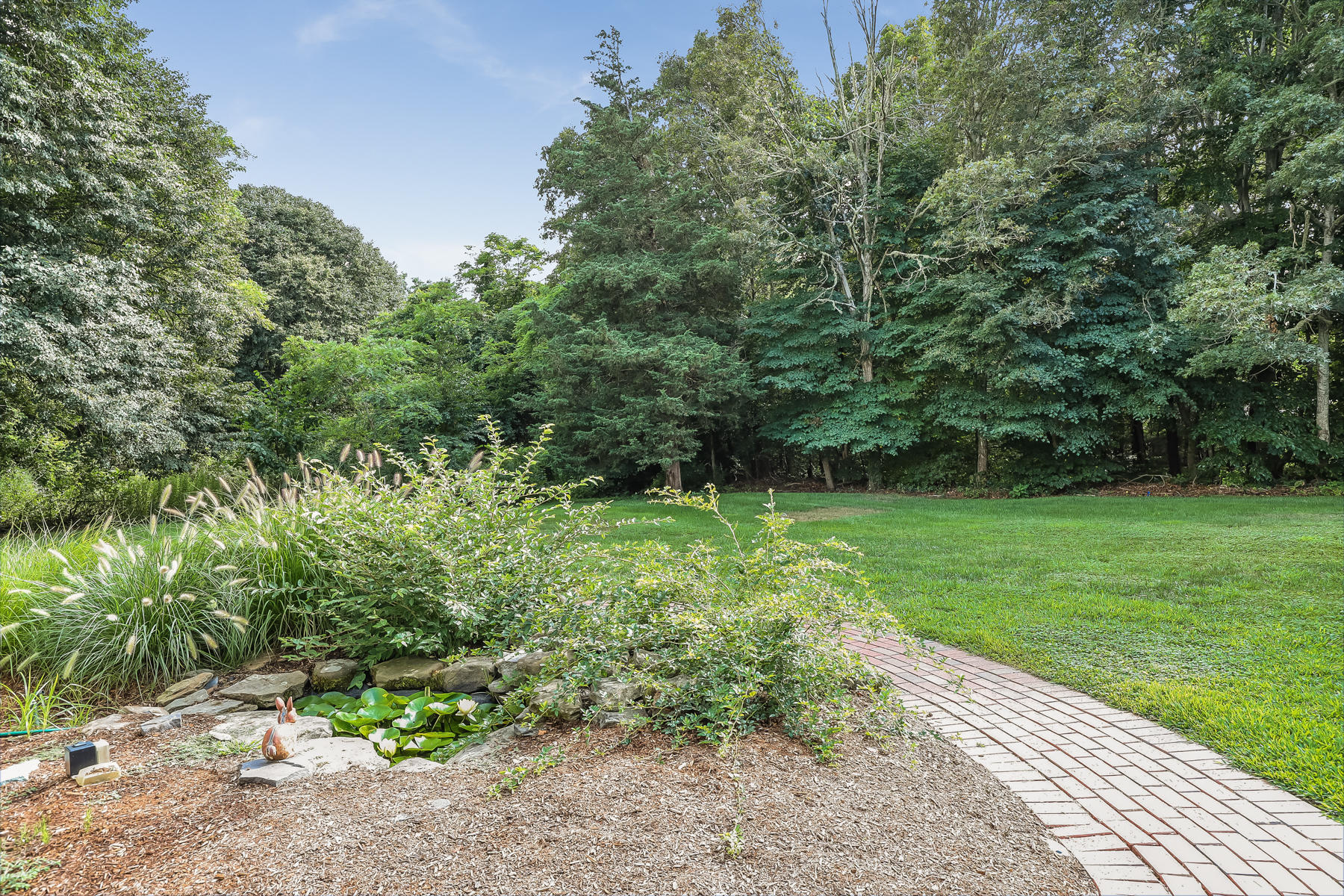 51 Meadow Farm Road Centerville, MA 02632 - Photo 39 of 45 a view of a garden with plants and large trees