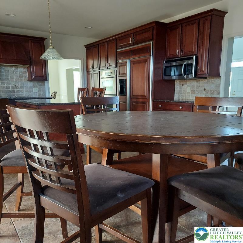 4704 Reston Drive Easton, PA 18040 - Photo 24 of 32 a kitchen with a table chairs microwave and cabinets