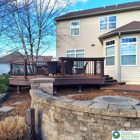 a view of a house with a wooden deck and a floor to ceiling window