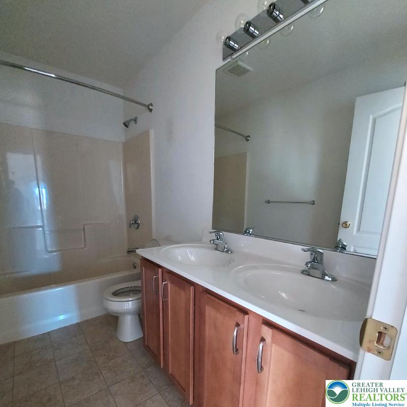 4704 Reston Drive Easton, PA 18040 - Photo 10 of 32 a bathroom with a granite countertop sink a toilet and a large mirror