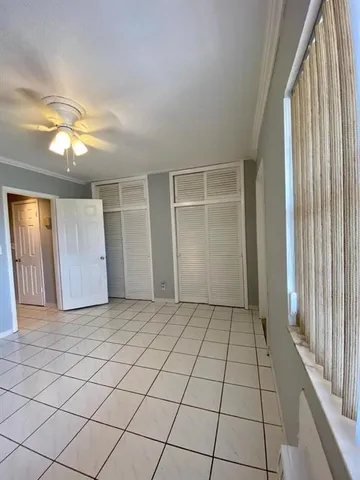 an empty room with fan and windows