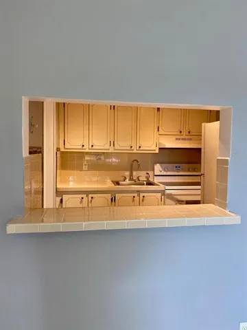 a kitchen with a sink a refrigerator and cabinets