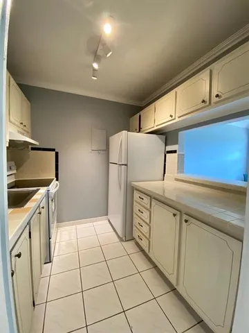a kitchen with white cabinets and white appliances