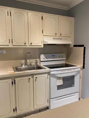 a kitchen with white cabinets and white appliances