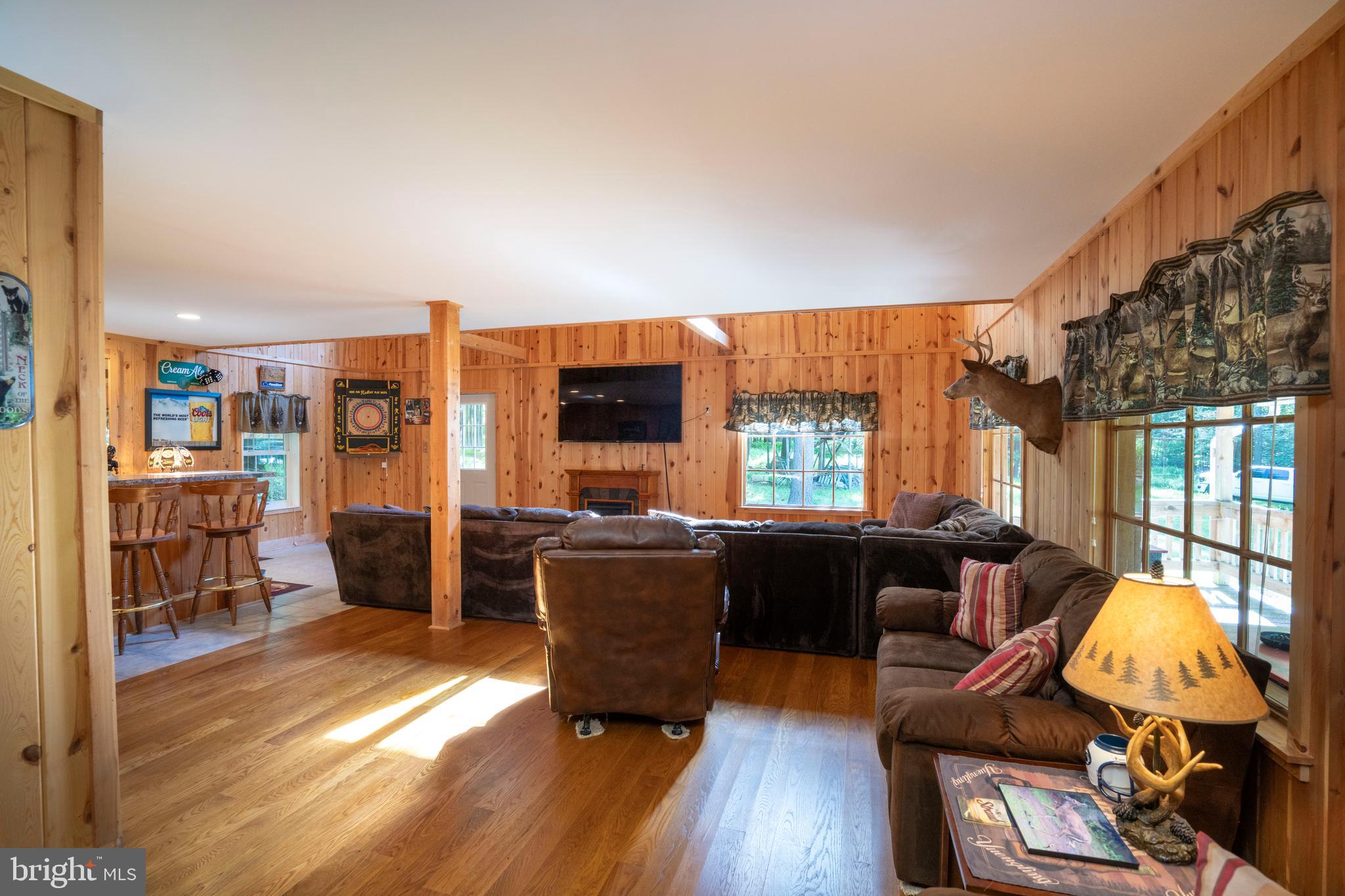 385 Elk Creek Road Aaronsburg, PA 16820 - Photo 13 of 71 a living room with furniture a large window and wooden floor