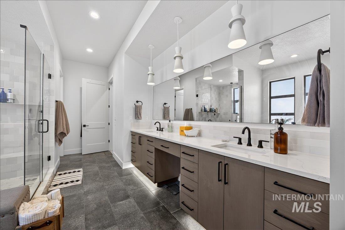 4718 East Goldstone Drive Meridian, ID 83642 - Photo 24 of 50 Full bathroom featuring double vanity, a shower stall, and tasteful backsplash