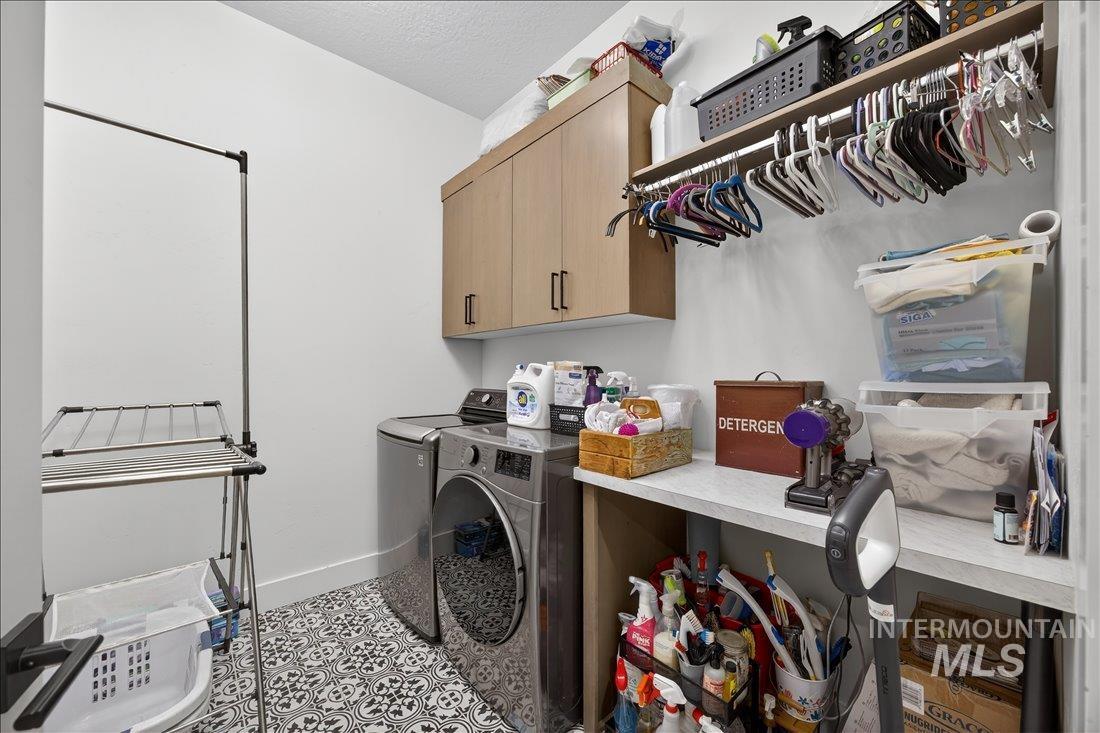 4718 East Goldstone Drive Meridian, ID 83642 - Photo 33 of 50 Laundry room with washing machine and dryer, cabinet space, and a textured ceiling