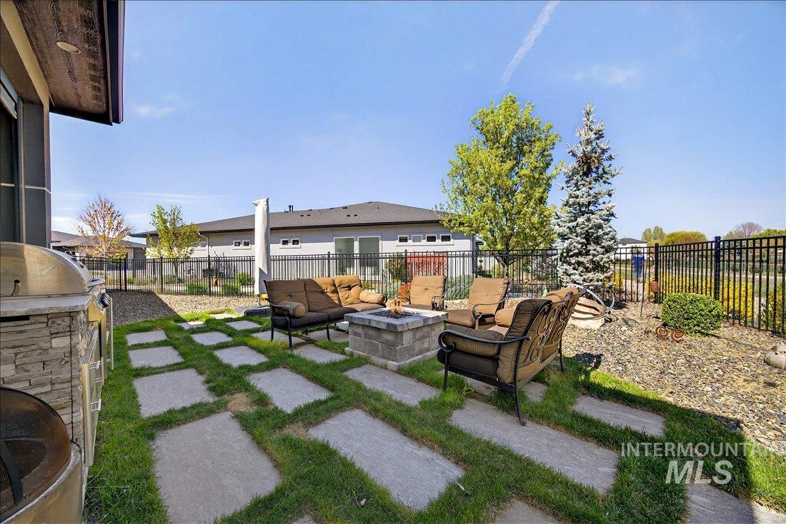 4718 East Goldstone Drive Meridian, ID 83642 - Photo 38 of 50 Fenced backyard featuring a patio, grilling area, and an outdoor living space with a fire pit