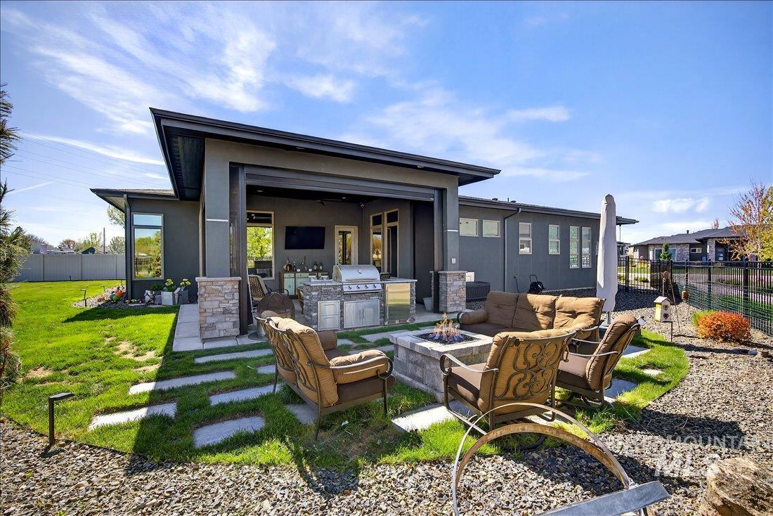 4718 East Goldstone Drive Meridian, ID 83642 - Photo 41 of 50 Rear view of property featuring an outdoor kitchen, a fire pit, a patio area, and stucco siding