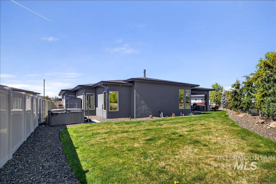 4718 East Goldstone Drive Meridian, ID 83642 - Photo 42 of 50 Rear view of house with a hot tub, stucco siding, and a fenced backyard