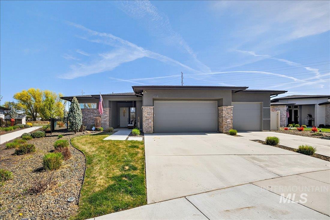 4718 East Goldstone Drive Meridian, ID 83642 - Photo 45 of 50 Prairie-style house featuring an attached garage, driveway, stone siding, and stucco siding