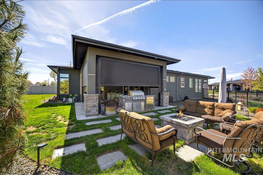 4718 East Goldstone Drive Meridian, ID 83642 - Photo 6 of 50 Rear view of property with an outdoor kitchen with living area, an outdoor fire pit, a patio, and stucco siding