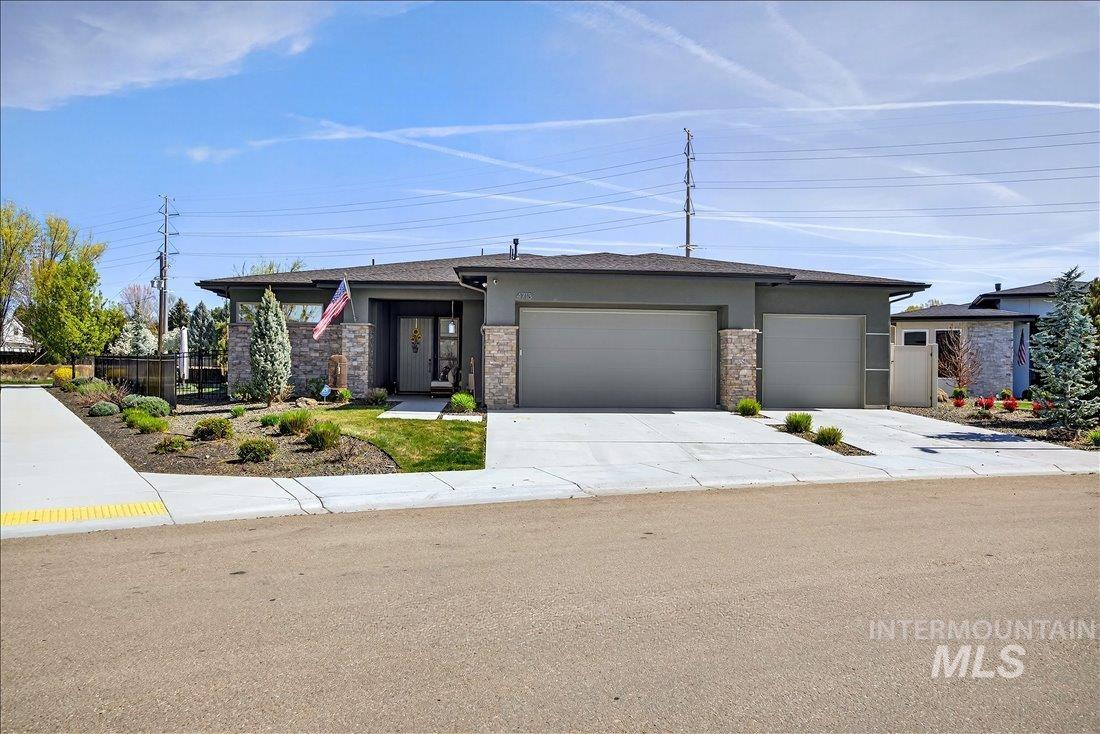 4718 East Goldstone Drive Meridian, ID 83642 - Photo 7 of 50 Prairie-style house featuring stucco siding, a garage, concrete driveway, and stone siding