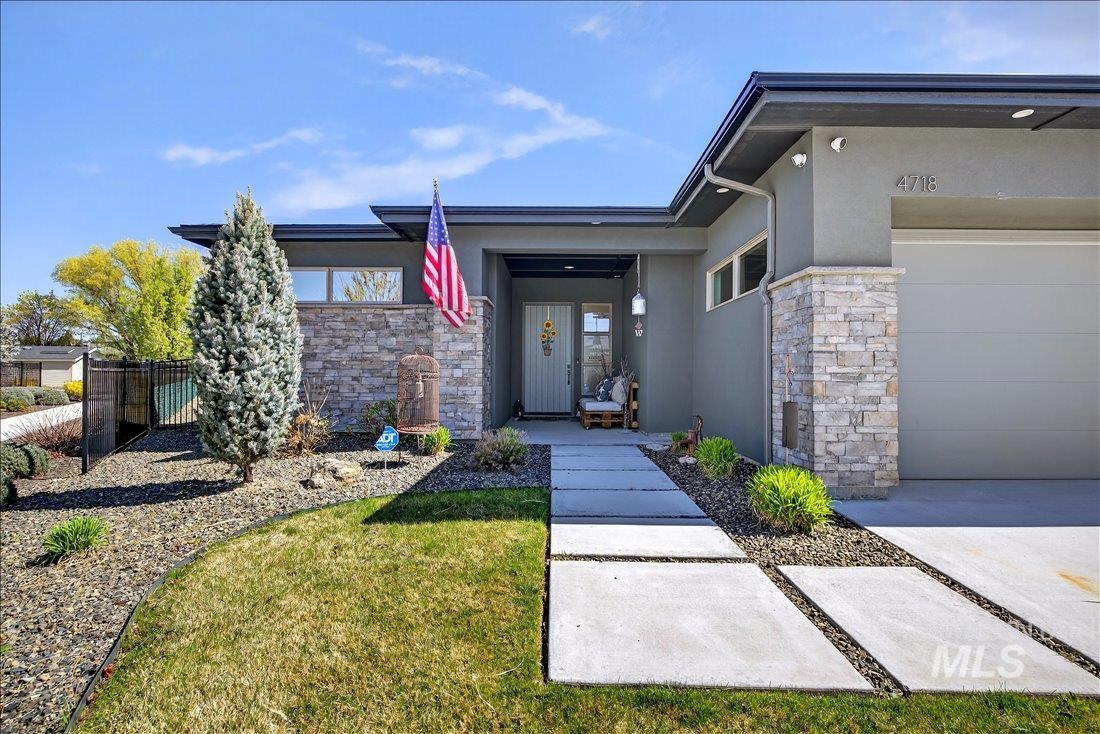 4718 East Goldstone Drive Meridian, ID 83642 - Photo 8 of 50 Entrance to property featuring stone siding, stucco siding, and an attached garage