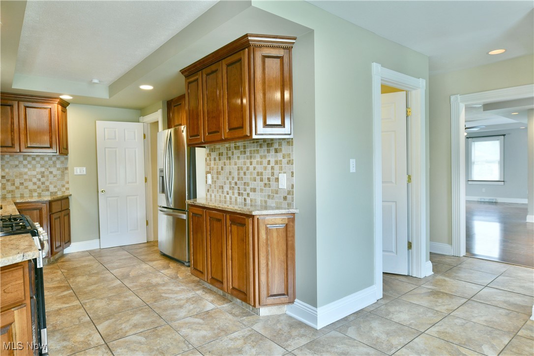 1735 Pleasant Valley Road Girard, OH 44420 - Photo 10 of 44 Kitchen with appliances with stainless steel finishes, backsplash, brown cabinetry, and recessed lighting