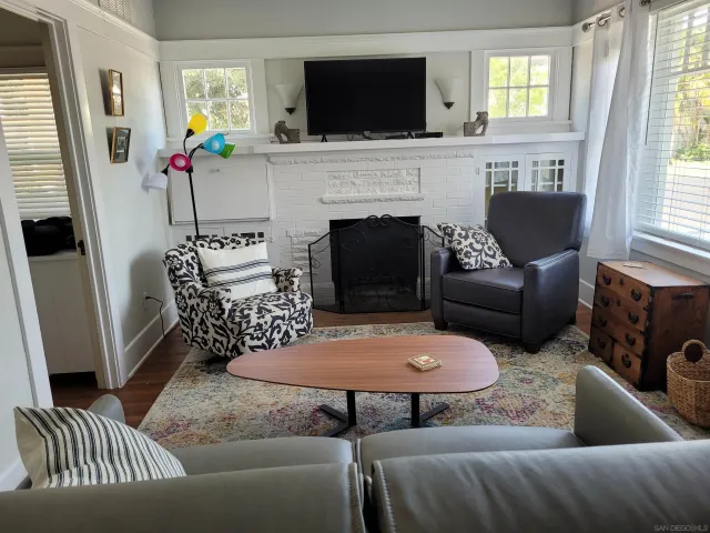 a living room with furniture a flat screen tv and a fireplace