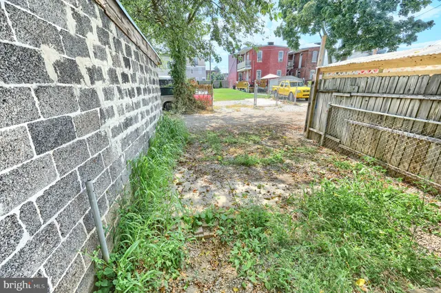 a view of a backyard with brick wall and potted plants
