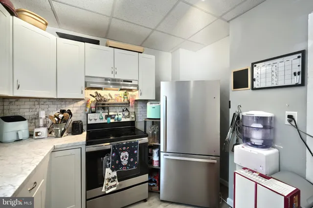 a kitchen with a refrigerator stove and cabinets
