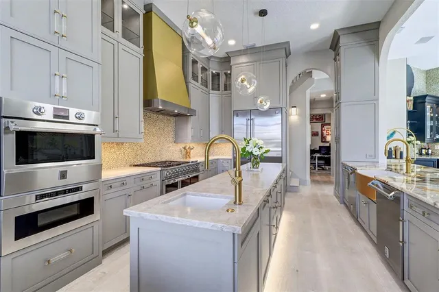 a large kitchen with stainless steel appliances granite countertop a stove and a sink