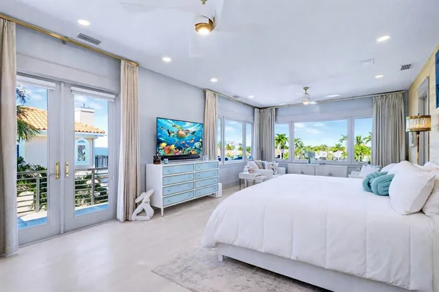 a spacious bedroom with a large bed and a flat screen tv