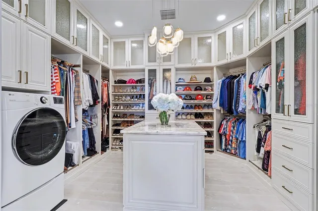 a view of walk in closet with clothes and shoes