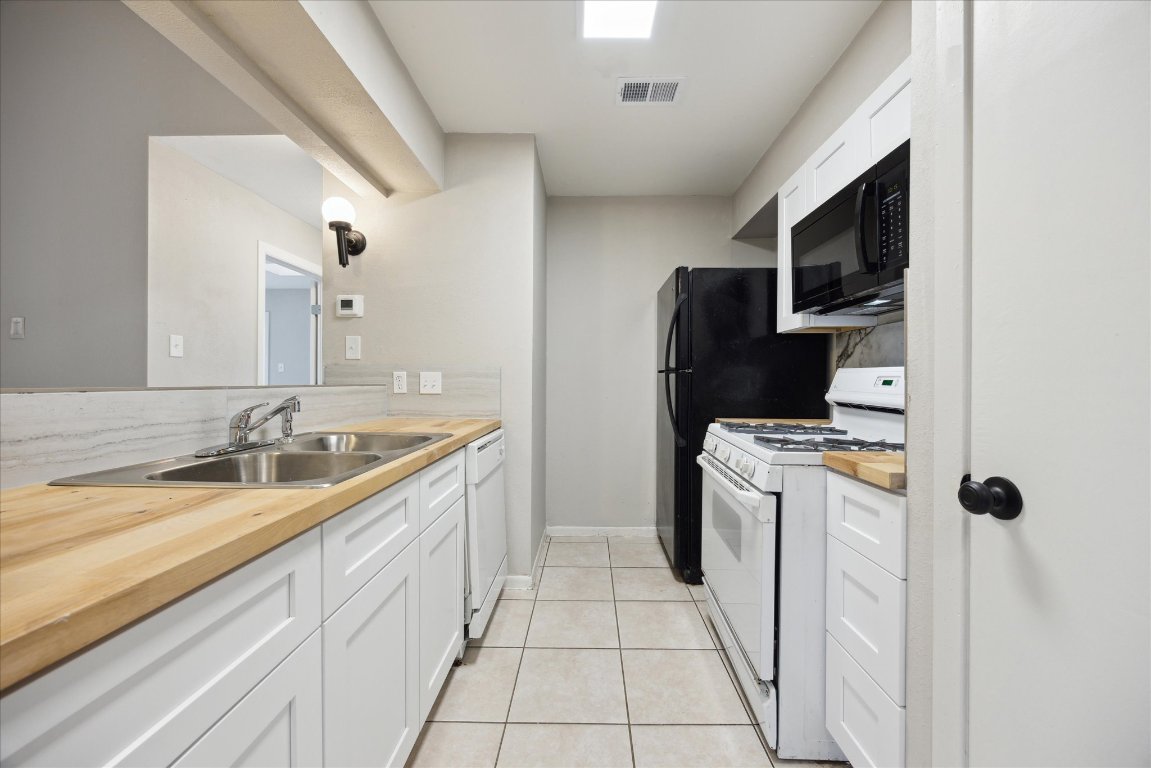 5300 B McCandless Street, Unit B Austin, TX 78756 - Photo 3 of 9 Kitchen with white cabinetry, visible vents, a sink, and white appliances