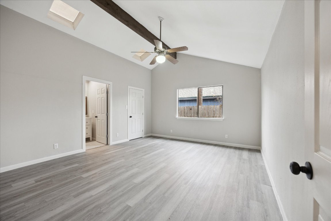 5300 B McCandless Street, Unit B Austin, TX 78756 - Photo 4 of 9 Unfurnished bedroom with a ceiling fan, light wood-type flooring, beam ceiling, baseboards, and ensuite bathroom