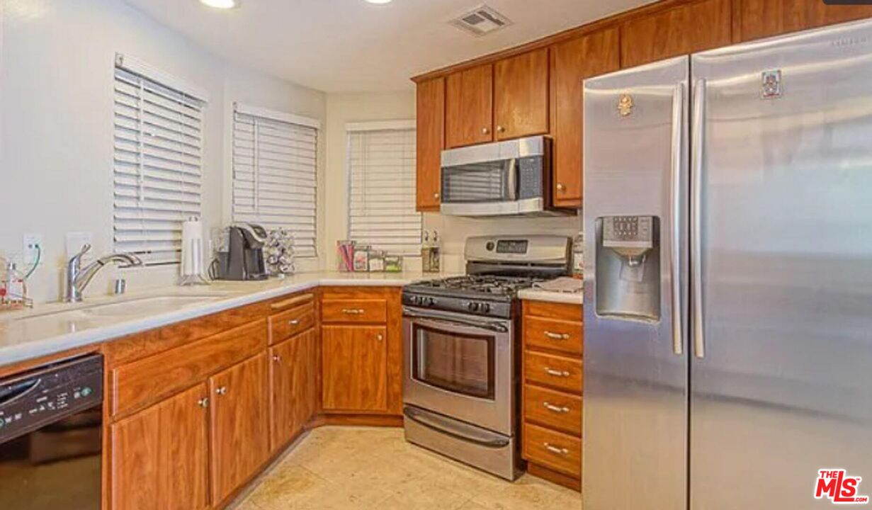 723 Westmount Drive, Unit 203 West Hollywood, CA 90069 - Photo 8 of 17 a kitchen with stainless steel appliances granite countertop a refrigerator and a sink