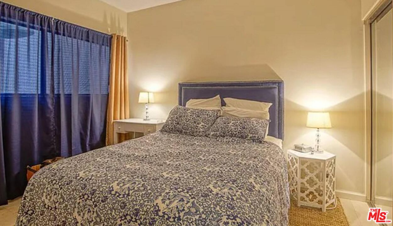 723 Westmount Drive, Unit 203 West Hollywood, CA 90069 - Photo 9 of 17 a large bed sitting in a bedroom next to a window and a mirror