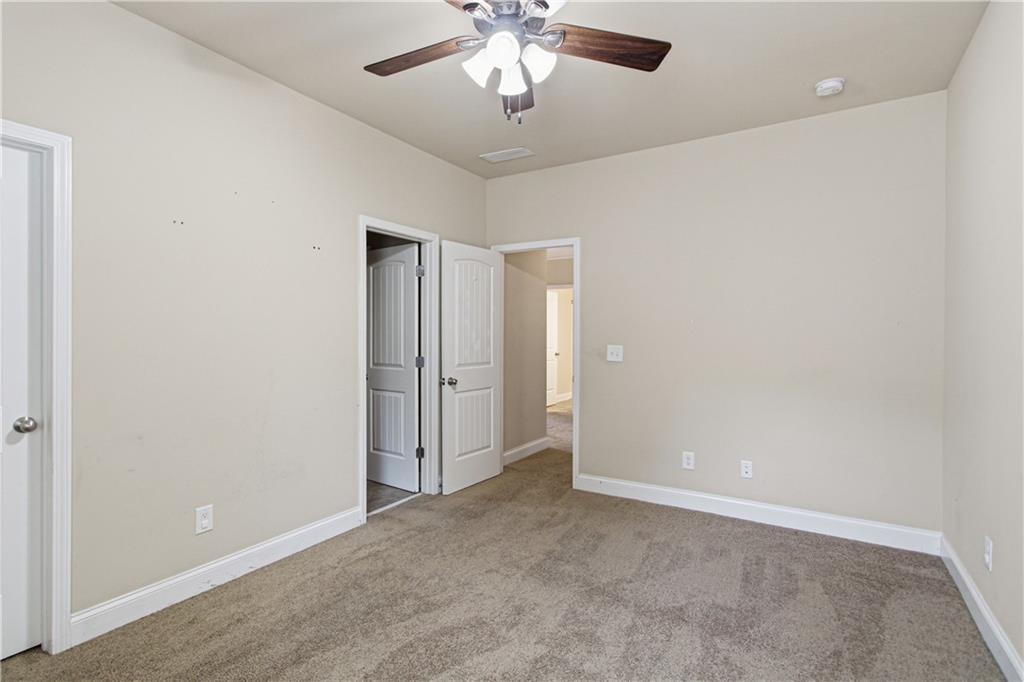 114 Madison Street Canton, GA 30115 - Photo 21 of 39 an empty room with a chandelier fan and windows
