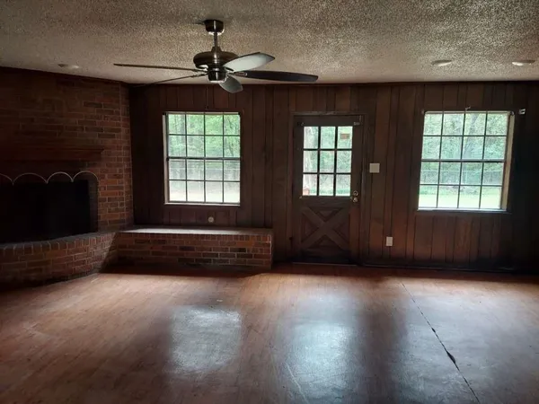 a living room with furniture a flat screen tv and windows