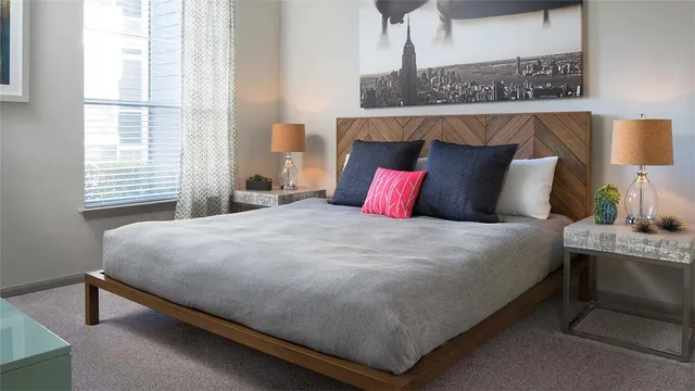 a bedroom with a bed lamp and a window