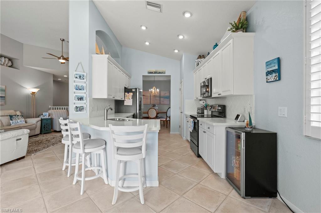 10422 Autumn Breeze Drive, Unit 201 Estero, FL 34135 - Photo 11 of 34 a kitchen with stainless steel appliances kitchen island granite countertop a sink and cabinets
