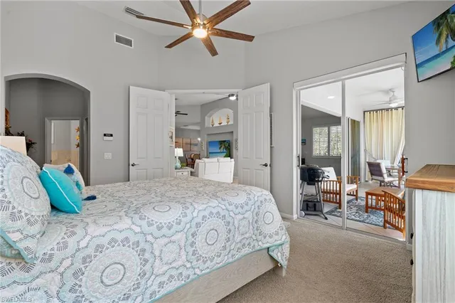 a bedroom with a large bed and a chandelier