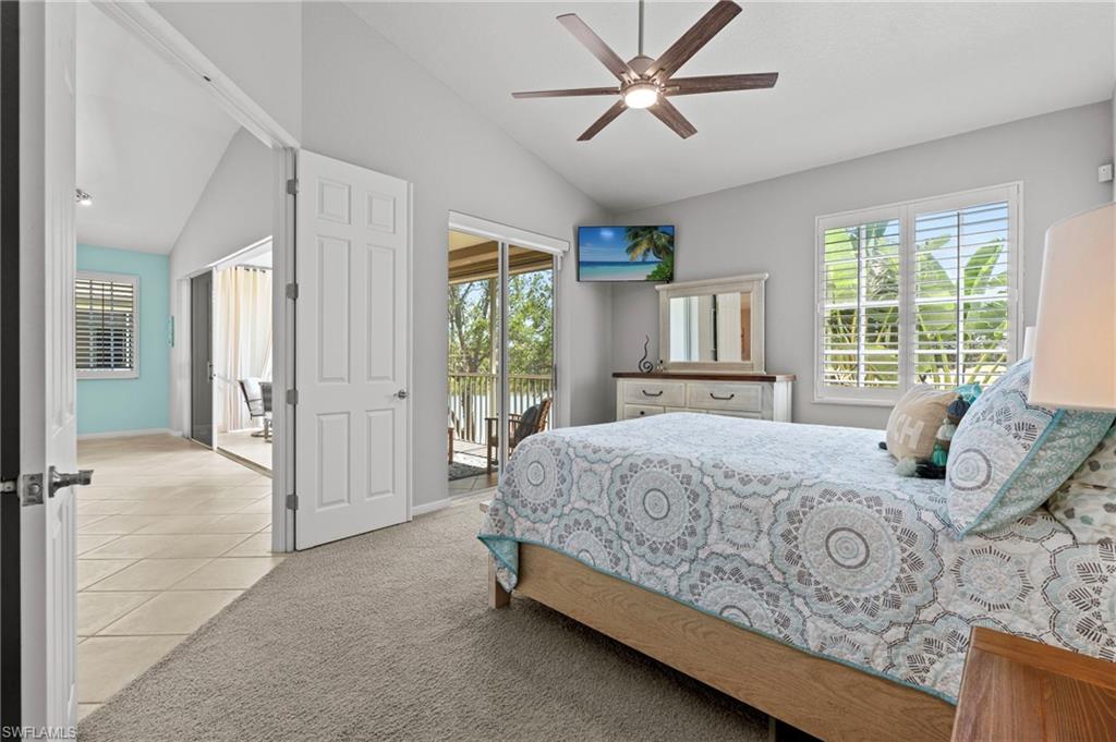 10422 Autumn Breeze Drive, Unit 201 Estero, FL 34135 - Photo 17 of 34 a bedroom with a large bed and a chandelier