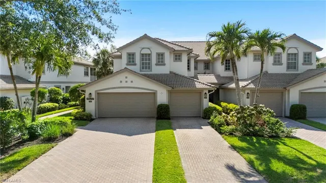 a front view of a house with a garden and trees