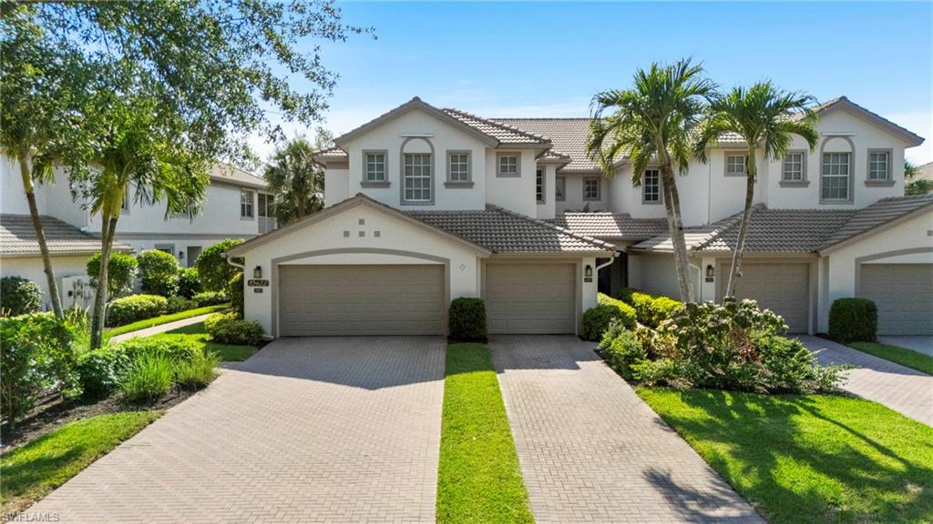 10422 Autumn Breeze Drive, Unit 201 Estero, FL 34135 - Photo 2 of 34 a front view of a house with a garden and trees