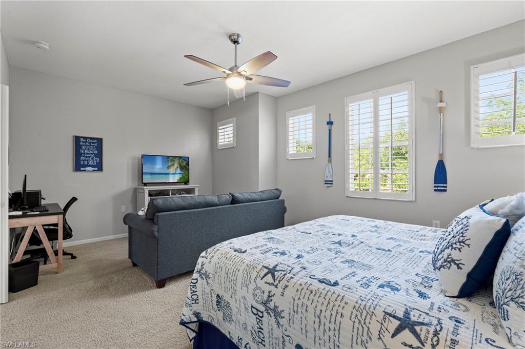 10422 Autumn Breeze Drive, Unit 201 Estero, FL 34135 - Photo 22 of 34 a bedroom with a bed and a chandelier