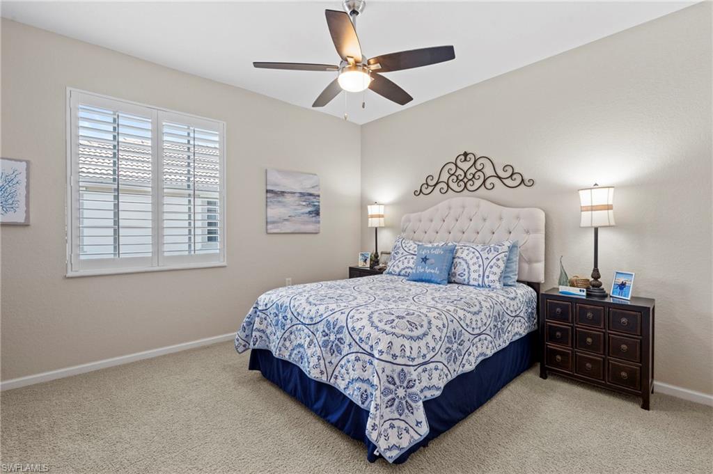 10422 Autumn Breeze Drive, Unit 201 Estero, FL 34135 - Photo 24 of 34 a bedroom with a bed and a chandelier