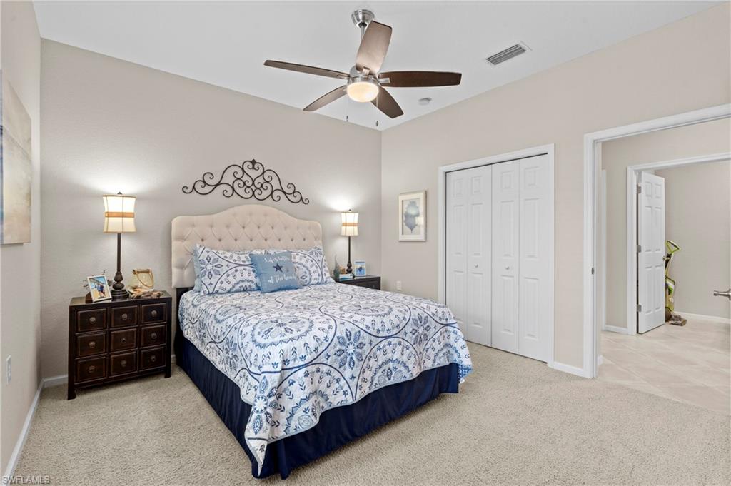 10422 Autumn Breeze Drive, Unit 201 Estero, FL 34135 - Photo 25 of 34 a bedroom with a bed and ceiling fan