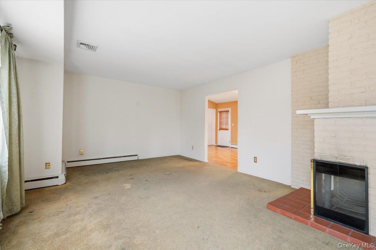 13 Jean Road West Islip, NY 11795 - Photo 4 of 25 a view of an empty room with a fireplace and a window