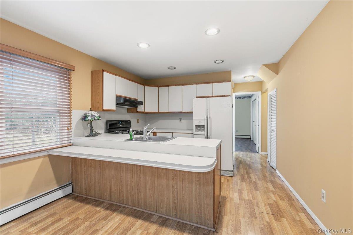 13 Jean Road West Islip, NY 11795 - Photo 9 of 25 a kitchen with stainless steel appliances granite countertop a sink a stove a refrigerator cabinets and a window