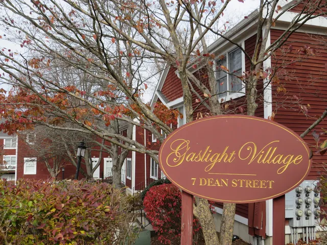 a sign board with a small yard and wooden fence