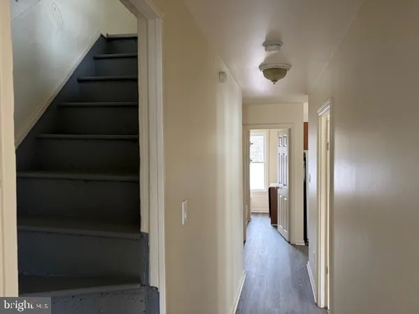 a view of a hallway with wooden floor and entryway