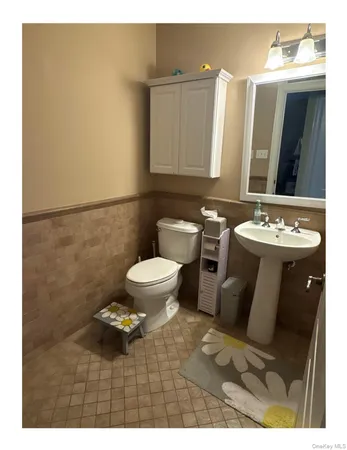 a bathroom with a sink toilet and mirror