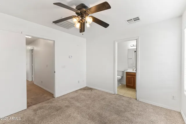 an empty room with chandelier fan and closet
